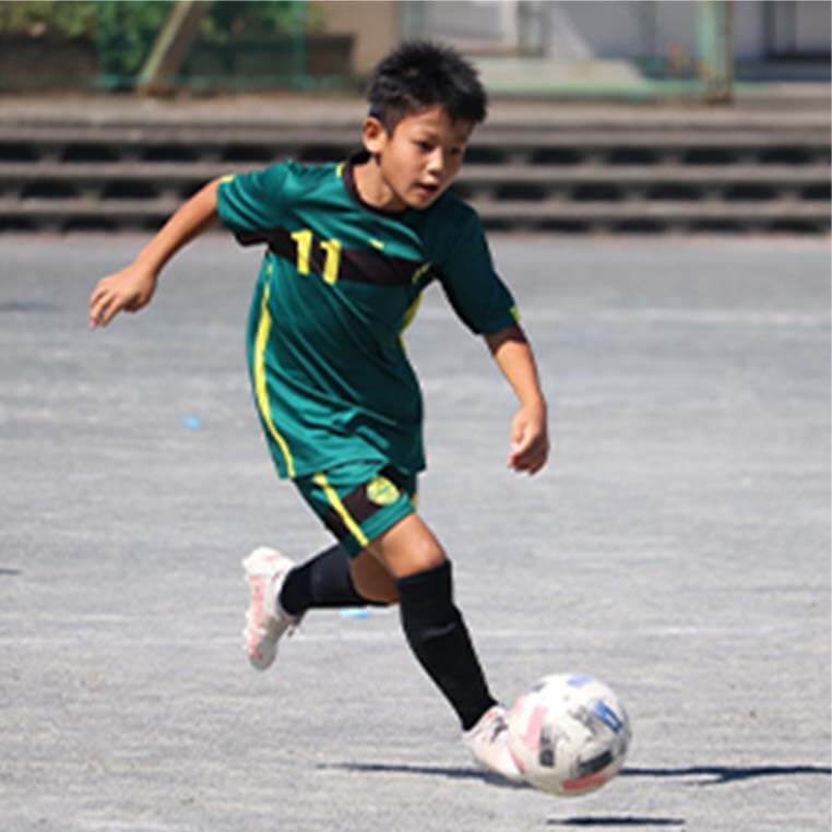 小学生のジョガドール静岡の選手がボールをける瞬間の写真